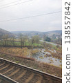 Scenic view of the village and marshland from the train window. Early spring, railway tracks, hills and village houses 138557842