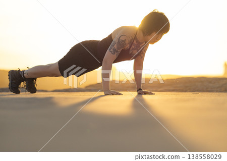 Woman exercising outdoors doing push-up at sunset 138558029