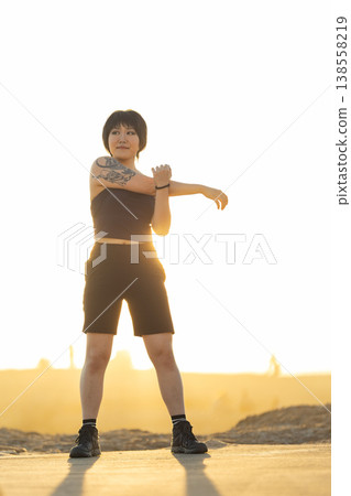 Young woman warming up arm stretching before workout Young woman warming up arm stretching before workout 138558219