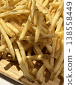 Close up of crispy french fries on wooden plate. Concept of fast food, snack, and unhealthy eating. Golden fried potatoes with crunchy texture and appetizing look. 138558449