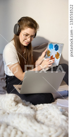 Young woman with headphones presenting tablet with diagram during coaching. 138558522