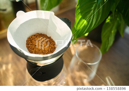 Ground coffee in paper filter dripper on glass carafe Ground coffee in paper filter dripper on glass carafe 138558896