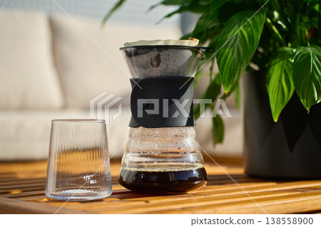Fresh brewed specialty coffee in dripper carafe with glass on table Fresh brewed specialty coffee in dripper carafe with glass on table 138558900