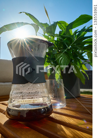 Filter coffee in pour over carafe on wooden table in sunlight Filter coffee in pour over carafe on wooden table in sunlight 138558901