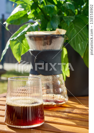 Glass of fresh filter coffee with pour over carafe on table 138558902