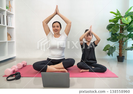 Mother and daughter practicing yoga at home 138558960