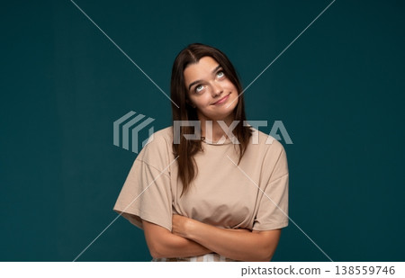 Young woman rolling her eyes showing sarcasm, annoyance, and indifference against a deep blue background 138559746