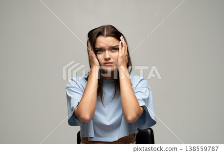 Young woman covering ears, experiencing stress, anxiety, tension, headache or mental health issues Young woman covering ears, experiencing stress, anxiety, tension, headache or mental health issues 138559787