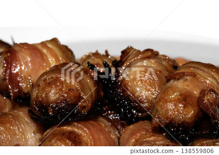 Close up of chipolatas pigs in blankets sausages wrapped in bacon on white background Close up of chipolatas pigs in blankets sausages wrapped in bacon on white background 138559806