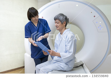 一名老年男子在接受CT掃描時,正在聽工作人員解釋。 一名老年男子在接受CT掃描時,正在聽工作人員解釋。 138559840
