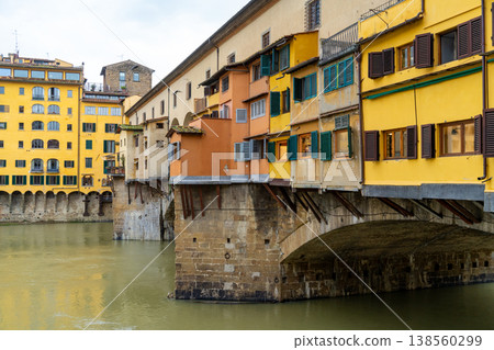 Iconic Ponte Vecchio bridge in Florence, Italy, featuring shops and houses built along its span over the Arno River 138560299