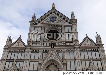 The ornate facade of the Basilica di Santa Croce, a masterpiece of Italian Gothic and Renaissance design, stands against a cloudy sky The ornate facade of the Basilica di Santa Croce, a masterpiece of Italian Gothic and Renaissance design, stands against a cloudy sky 138560400