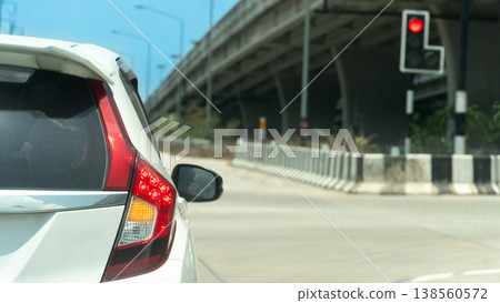 Transport of vehicle car white color with turn on brake and turn right signal. Stop first car on the junction of concrete road with overpass in front. Transport of vehicle car white color with turn on brake and turn right signal. Stop first car on the junction of concrete road with overpass in front. 138560572