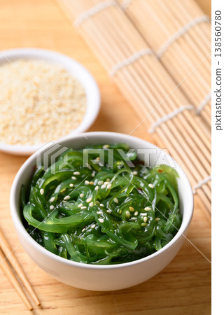 Fresh Japanese seaweed salad (Chuka Wakame) in a bowl and chopsticks on wooden background Fresh Japanese seaweed salad (Chuka Wakame) in a bowl and chopsticks on wooden background 138560780
