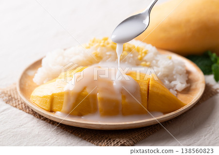 Pouring coconut milk sauce on Mango sticky rice (Khao Niew Mamuang) 138560823