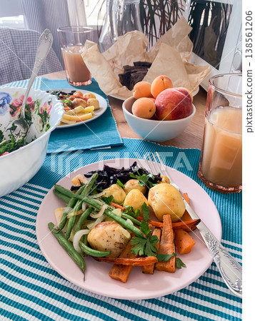 A table displays a healthy breakfast with baked potatoes, sweet potatoes, carrots, green beans, salad, and fresh fruit like apricots and peaches, perfect for starting the day A table displays a healthy breakfast with baked potatoes, sweet potatoes, carrots, green beans, salad, and fresh fruit like apricots and peaches, perfect for starting the day 138561206