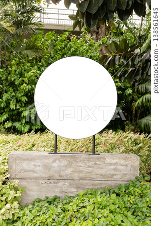 This is an empty storefront featuring a blank sign that provides copy space for a logo or branding. The storefront is situated in a retail area with greenery and outdoor plants 138561645