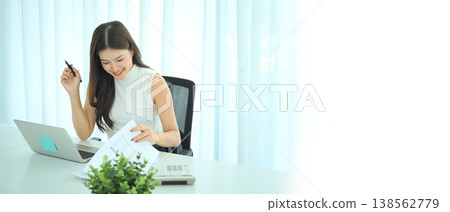 Professional woman reading financial documents at modern office desk Professional woman reading financial documents at modern office desk 138562779