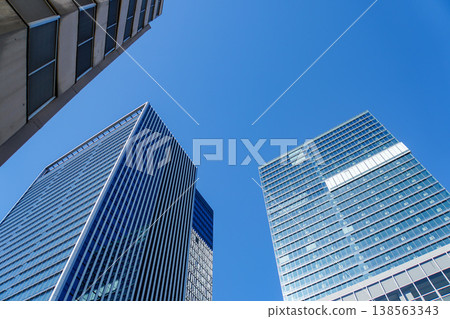 在湛藍的天空下，一排現代高層辦公大樓筆直地延伸在前方。 138563343