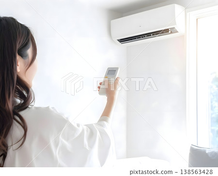 女人的手將室溫調整到舒適的程度。 女人的手將室溫調整到舒適的程度。 138563428