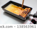 Cook an omelet and burn it. 138563961