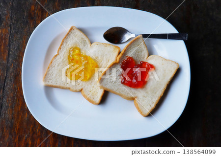 Fresh Pineapple jam and strawberry jam with bread on white dish for breakfast on wooden table 138564099