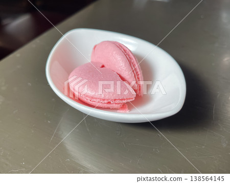 A sweet, pink macaron cut in half. A sweet, pink macaron cut in half. 138564145