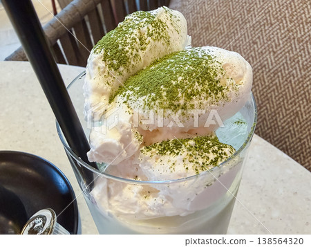 Whipped cream and matcha powder on top of a matcha latte. Whipped cream and matcha powder on top of a matcha latte. 138564320