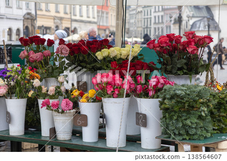 Vibrant flower stall offering fresh, colorful bouquets of roses and mixed blooms in white vases with prices, creating a lively urban market view Vibrant flower stall offering fresh, colorful bouquets of roses and mixed blooms in white vases with prices, creating a lively urban market view 138564607