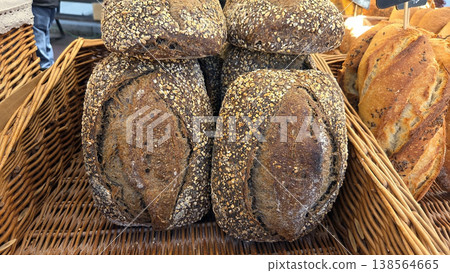 Whole grain seeded loaves in wicker basket at farmers market for bakery poster and rustic food background Whole grain seeded loaves in wicker basket at farmers market for bakery poster and rustic food background 138564665