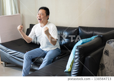 Celebration and Success Moment, A man cheers with excitement, raising his fists in celebration, expressing happiness and the joy of success. Celebration and Success Moment, A man cheers with excitement, raising his fists in celebration, expressing happiness and the joy of success. 138564713
