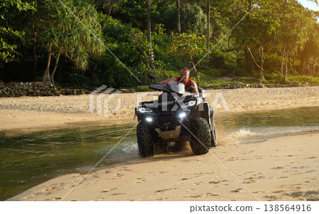 A man engages in extreme ATV riding on sand beach early in the morning A man engages in extreme ATV riding on sand beach early in the morning 138564916