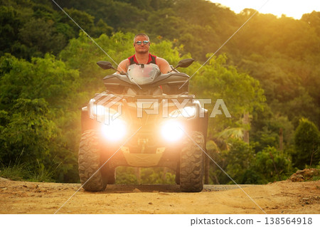 A man engages in extreme ATV riding on mountains in the evening A man engages in extreme ATV riding on mountains in the evening 138564918