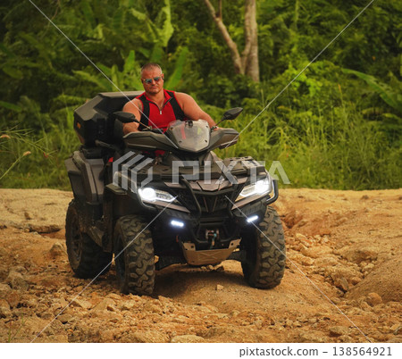 A man engages in extreme ATV riding on mountains in the evening A man engages in extreme ATV riding on mountains in the evening 138564921