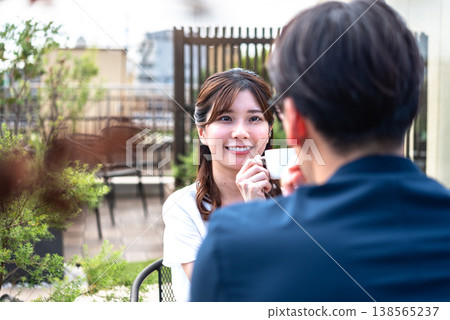 A lifestyle featuring a man and a woman enjoying tea time on a bright terrace. A lifestyle featuring a man and a woman enjoying tea time on a bright terrace. 138565237