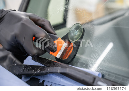 Repairing a chip on a car windshield. Repairing a chip on a car windshield. 138565574