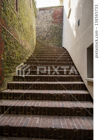Narrow brick staircase between old walls leading upward urban architecture perspective and historic alley concept Narrow brick staircase between old walls leading upward urban architecture perspective and historic alley concept 138565733