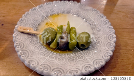 Skewered green olives with anchovy and pickled pepper on decorative ceramic plate for spanish tapas appetizer and bar snack presentation. Gilda, spanish tapas Skewered green olives with anchovy and pickled pepper on decorative ceramic plate for spanish tapas appetizer and bar snack presentation. Gilda, spanish tapas 138565858