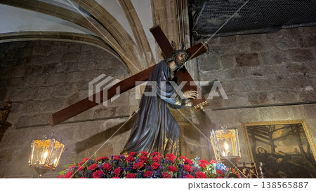 Religious statue of christ carrying cross with flowers and lanterns inside church for holy week procession background and ceremonial display 138565887