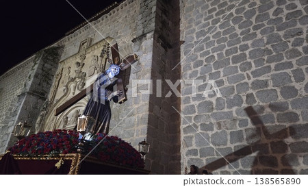 Night exterior stone church with religious statue of jesus casting a shadow during semana santa holy week procession for banner design Night exterior stone church with religious statue of jesus casting a shadow during semana santa holy week procession for banner design 138565890
