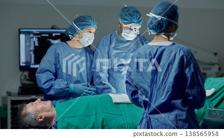 Teamwork, hospital and doctors working on a surgery for medical treatment in a theatre room. Collaboration, career and professional surgeons doing a healthcare operation on a patient in a clinic. Teamwork, hospital and doctors working on a surgery for medical treatment in a theatre room. Collaboration, career and professional surgeons doing a healthcare operation on a patient in a clinic. 138565958