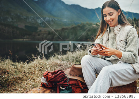 Nature, smile and woman on a phone for hiking on a mountain and network on social media or mobile app. Happy, technology and young female person scroll on internet with cellphone in outdoor forest. Nature, smile and woman on a phone for hiking on a mountain and network on social media or mobile app. Happy, technology and young female person scroll on internet with cellphone in outdoor forest. 138565993