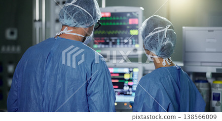 Teamwork, screen monitor or surgeon in surgery procedure or healthcare operation in hospital. Night, back view or doctors in face mask working or helping in dark operating room in medical clinic 138566009