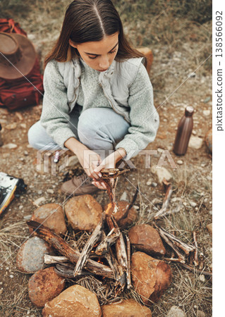 Wood, nature and woman with fire on a camp on a mountain for adventure, weekend trip or vacation. Stone, sticks and young female person making a flame or spark in outdoor woods or forest for holiday. Wood, nature and woman with fire on a camp on a mountain for adventure, weekend trip or vacation. Stone, sticks and young female person making a flame or spark in outdoor woods or forest for holiday. 138566092