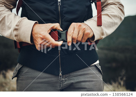 Closeup hands, man and nature fastening a backpack for hiking, trekking or travel in the mountains. Walking, buckle clip and a tourist with a bag in the woods for activity, fitness and exercise Closeup hands, man and nature fastening a backpack for hiking, trekking or travel in the mountains. Walking, buckle clip and a tourist with a bag in the woods for activity, fitness and exercise 138566124
