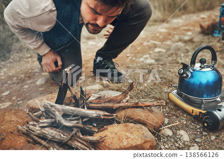 Wood, nature and man with fire on camp for kettle on an outdoor adventure, vacation or weekend trip. Stones, sticks and young male person blowing for flame or smoke in the forest on holiday in Canada Wood, nature and man with fire on camp for kettle on an outdoor adventure, vacation or weekend trip. Stones, sticks and young male person blowing for flame or smoke in the forest on holiday in Canada 138566126