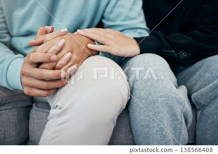 Empathy, holding hands and closeup of couple on a sofa with support, love or trust in their home. Hope, kindness and zoom on people touching in a living room with solidarity, respect or grief comfort 138566408