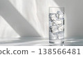 tall glass of water with ice cubes on the table, white background, light gray tabletop 138566481