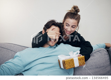 Surprise, gift and couple on a sofa for birthday, celebration or anniversary at home. Gift, box and people in a living room with guess game for present, romance or congratulations gesture in a house Surprise, gift and couple on a sofa for birthday, celebration or anniversary at home. Gift, box and people in a living room with guess game for present, romance or congratulations gesture in a house 138566495