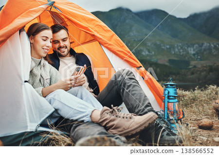 Couple, tent and camping with phone, smile and reading for holiday, web blog and morning in countryside. Man, woman and relax with vacation, social media and adventure with love, outdoor and freedom 138566552